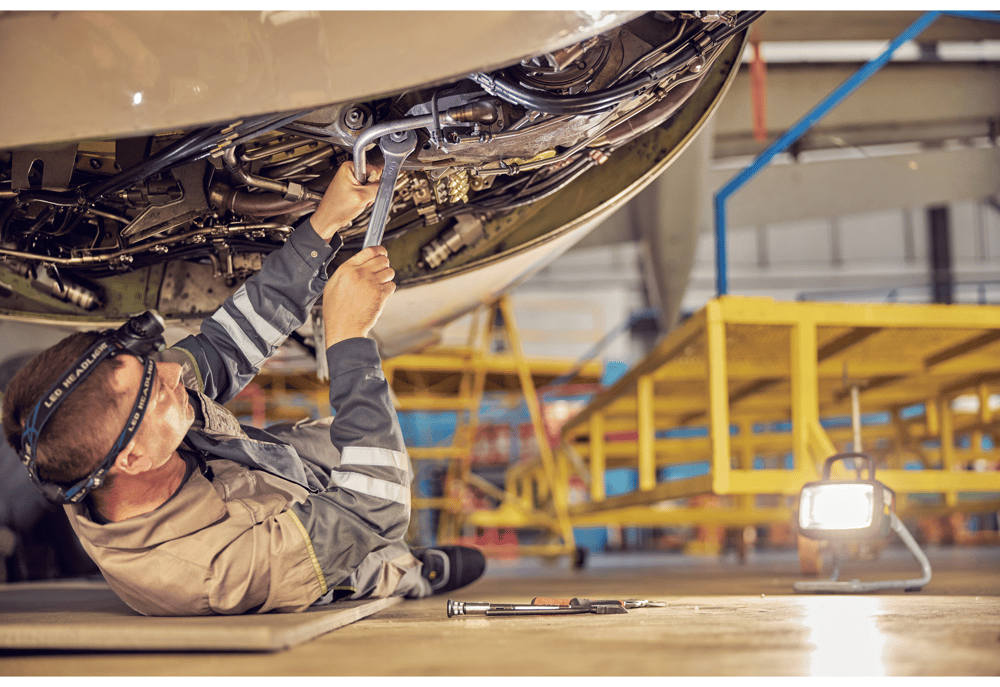 A defence contractor mechanic checking a jet before departure.