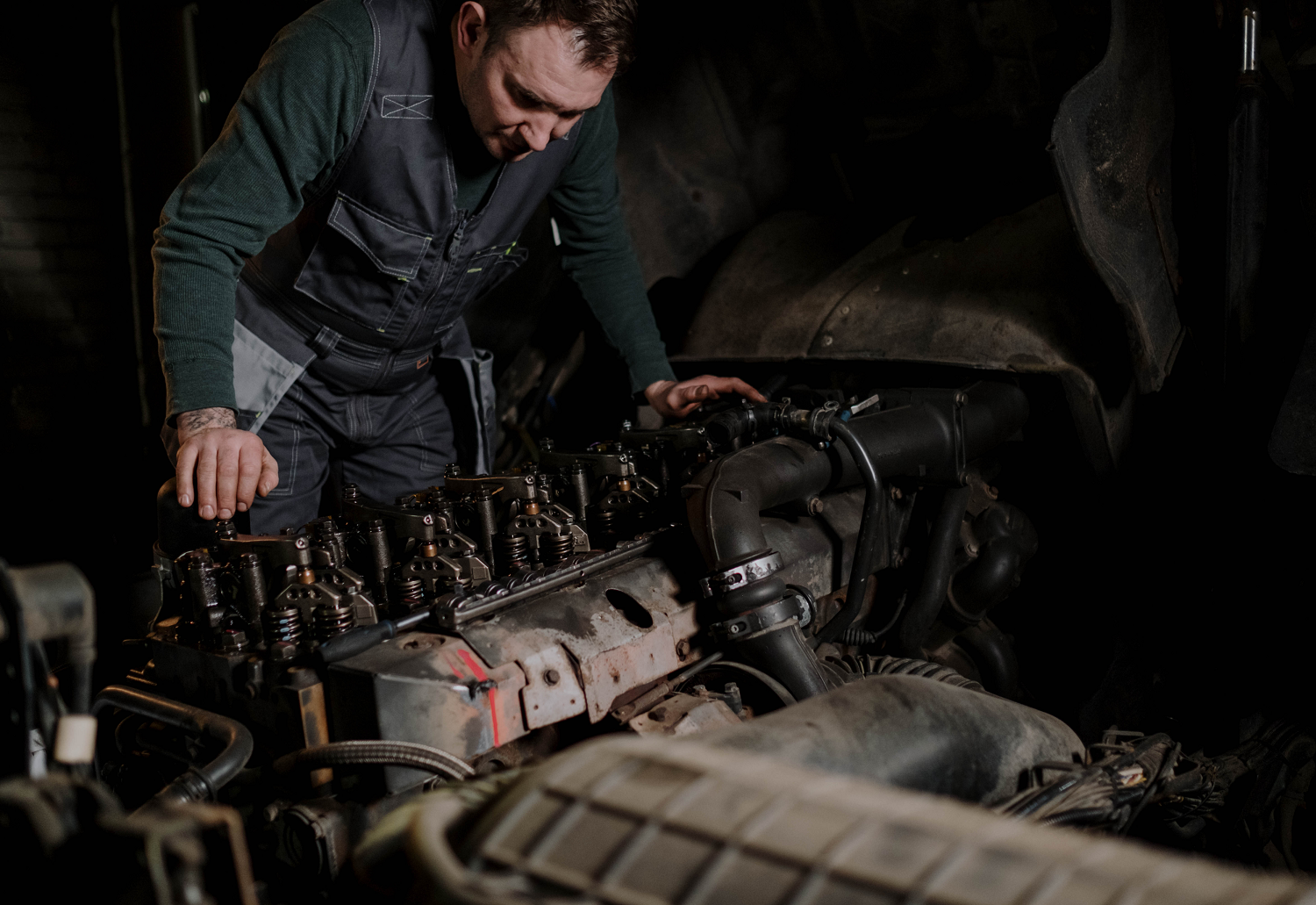 A mechanic working on a vehicle engine.