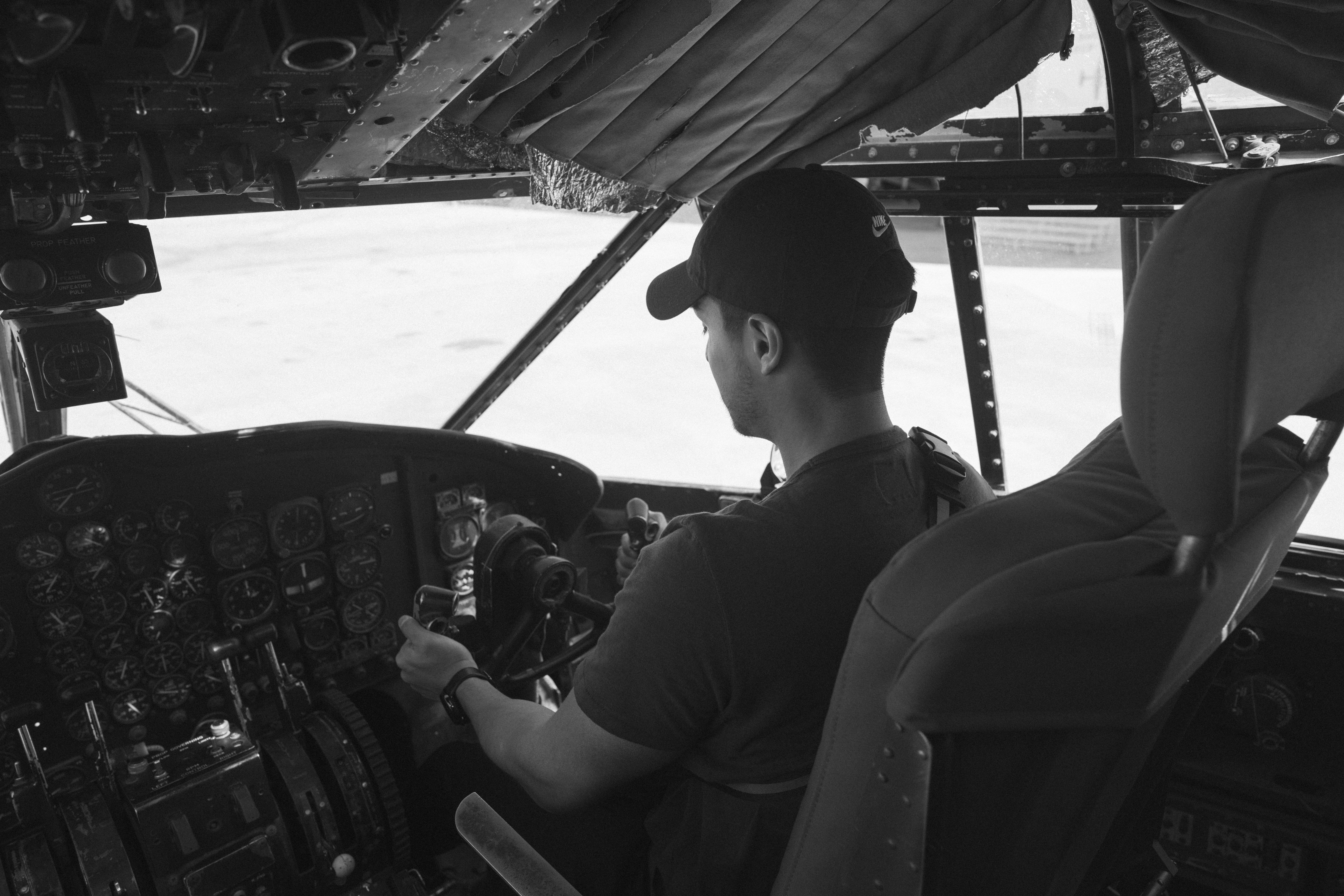 Canva - Grayscale Photo of Man Flying A Plane