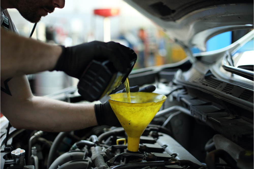 HGV mechanic pouring oil into a HGV engine