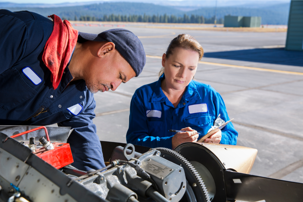 two airplaine mechanics, male and female, working on plane